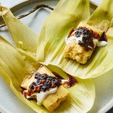 A tamale partially unwrapped from its corn husk