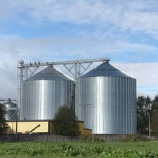 A tall cylindrical farm silo used for storing grain.