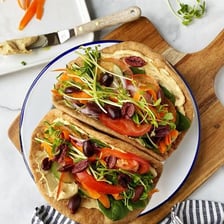 Round pita bread served beside a bowl of hummus