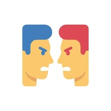 Two people arguing face to face, illustrating the phrase “at it.”