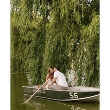 A rowing oar resting beside a small boathouse.