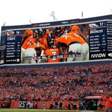 A sports scoreboard displaying DEN for the Denver Broncos
