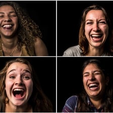 A person laughing with an open, cheerful expression.
