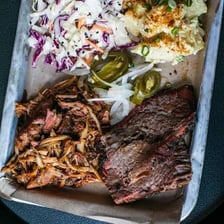 A serving of shredded coleslaw beside barbecue food