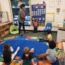 Young children sitting in a circle during a preschool class
