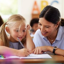 A teaching assistant assisting students in a classroom