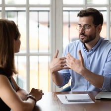One person listening as another speaks during a conversation.