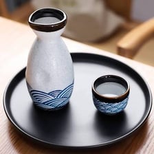 A bottle of Japanese sake beside traditional serving cups