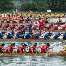 Teams paddling decorated dragon boats in a race