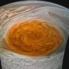 Jupiter viewed from space with its large reddish Great Red Spot visible.