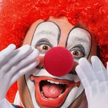 A clown wearing a bright red nose