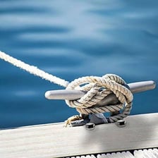 A boat secured to a dock with a mooring rope