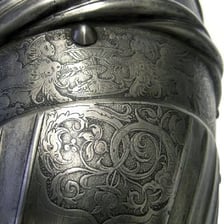 An artist etching a design into a metal plate