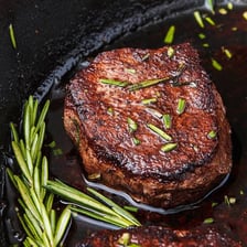 A cooked filet mignon steak served on a plate.