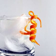 A strip of citrus rind used to garnish a cocktail