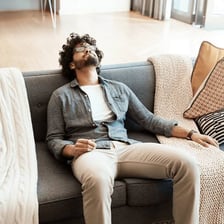 A person relaxing idly on a couch