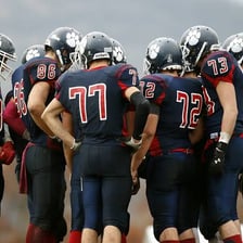 A sports team gathered together in a huddle