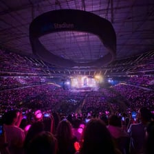 A large indoor arena filled with concert spectators