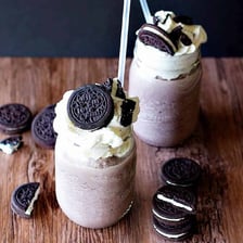 A cookies-and-cream milkshake garnished with cookie pieces.