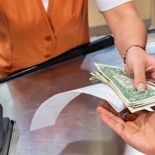 A person paying for a purchase with cash.
