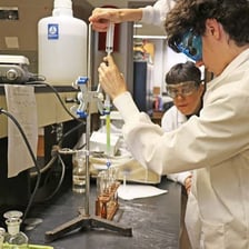 Students conducting a chemistry experiment in a high school laboratory.