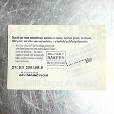 A bakery sign stating a one-sample-per-customer limit
