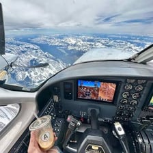 A pilot operating an airplane from the cockpit.