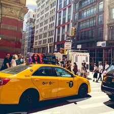 A yellow taxi cab on a city street