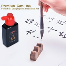 A bottle of black ink beside a calligraphy brush.