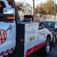 Tow truck providing roadside assistance to a disabled car