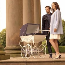 A baby pram on a sidewalk.