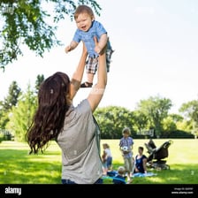 An adult lifting a laughing child in a playful moment