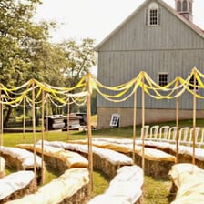 A rectangular hay bale set out as seating at an outdoor gathering.