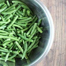 Fresh green string beans showing their trimmed ends.