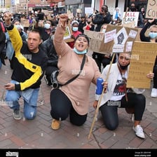 A person kneeling during a public protest.