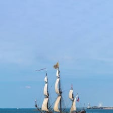 A ship sailing away from a harbor