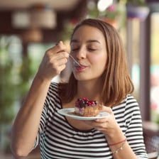 A person reacting happily to a delicious dessert.
