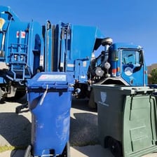 A garbage truck collecting household waste bins