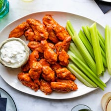 A plate of spicy Buffalo chicken wings with dipping sauce