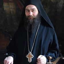A robed abbot in a monastery setting