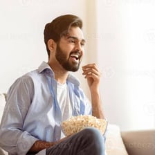A person relaxing on a couch while watching television.