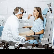 An ear, nose, and throat specialist examining a patient’s throat.
