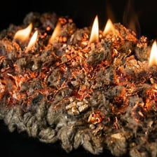 A glowing ember among the remains of a burned-down fire.