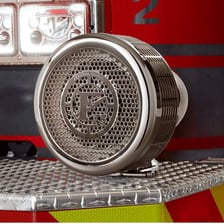 A red emergency siren mounted on a fire engine.