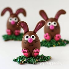 A chocolate bunny displayed with decorated Easter eggs.