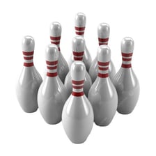 Ten bowling pins arranged in a triangular formation at the end of a bowling lane.