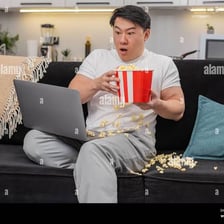 A person watching a frightening movie with a tense expression