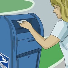 A person placing a stamped letter into a mailbox.