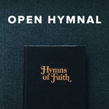 An open hymnal resting on a church pew