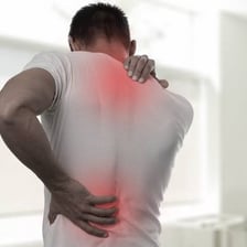 A person holding a sore shoulder or muscle.